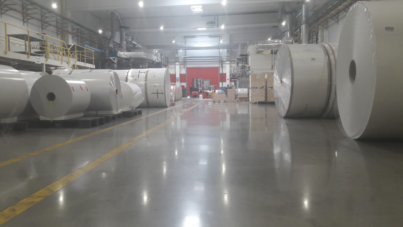 Bobinas de papel almacenadas sobre una solera en una fábrica