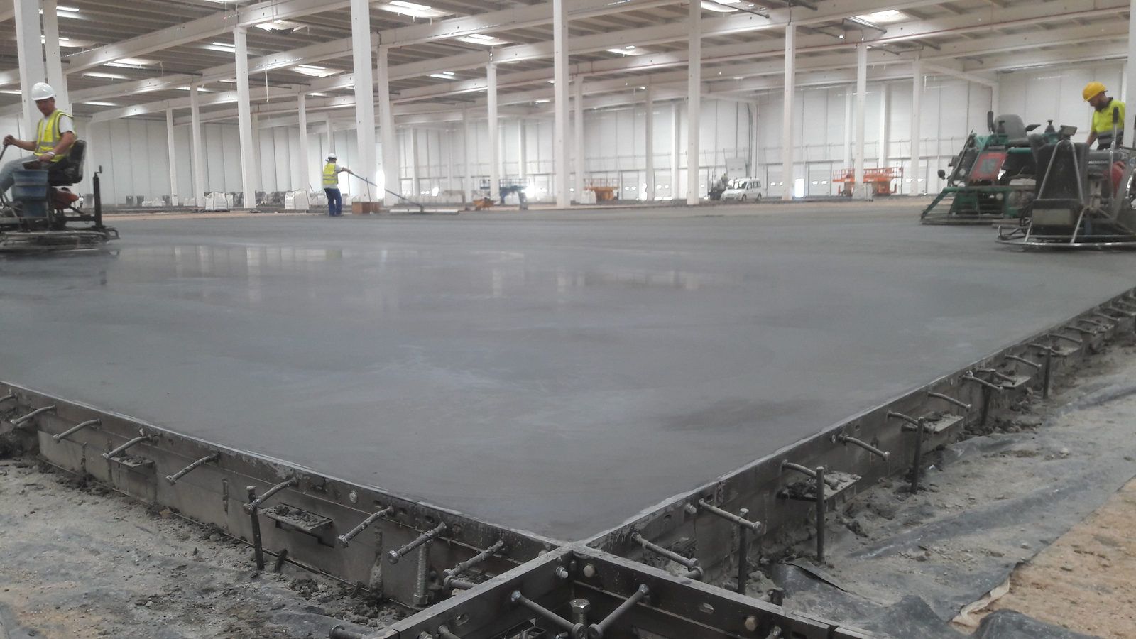 Losa de hormigón recién extendida en una nave de grandes dimensiones